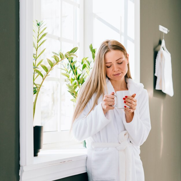 Fille ayant un café à la salle de bain