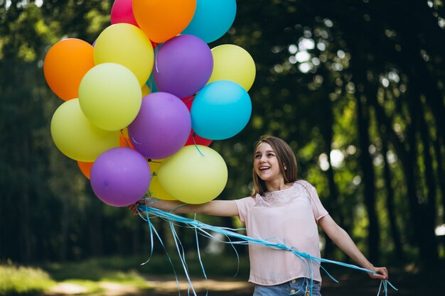 Fille avec des ballons dans le parc