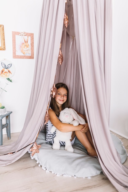 Fille avec des ballons et des jouets sous la tente