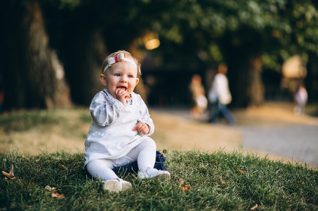 Fille de bambin assis sur l&#39;herbe dans le parc