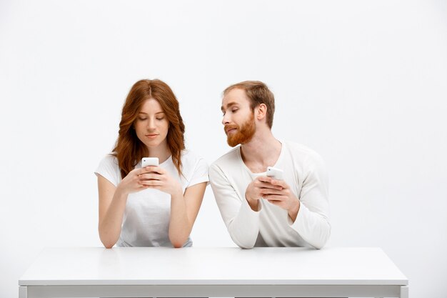 Fille bavardant, l'homme regarde son téléphone portable