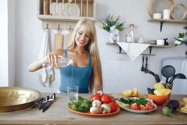 Fille belle et sportive dans une cuisine avec un légume