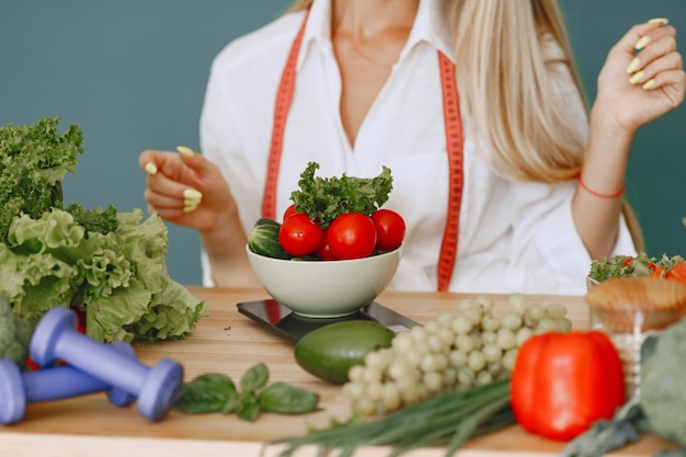 Fille belle et sportive dans une cuisine avec un légumes