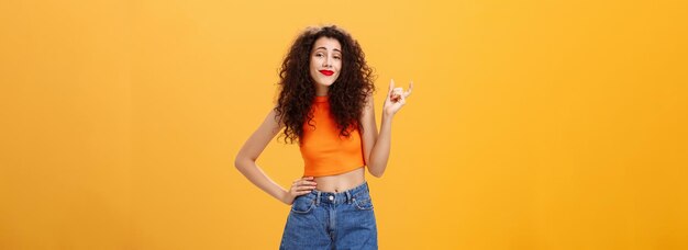 La fille a besoin d'une plus grande taille pour impressionner une femme urbaine élégante et insouciante avec une coiffure bouclée à lèvres rouges