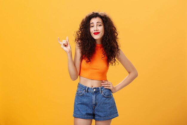 La fille a besoin d'une plus grande taille pour impressionner une femme urbaine élégante et insouciante avec une coiffure frisée rouge à lèvres ...