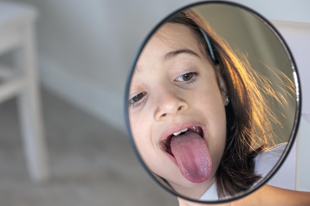 Photo gratuite une fille blanche avec des appareils dentaires en train de regarder dans le miroir.