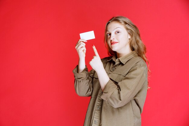 Fille blonde montrant sa carte de visite et son réseautage.