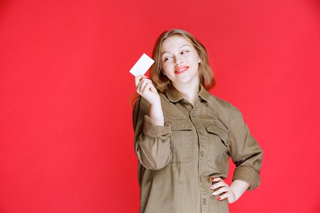 Fille blonde montrant sa carte de visite et son réseautage.