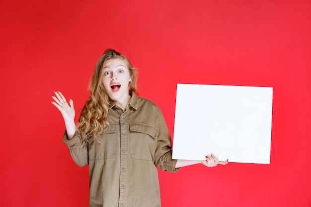 Fille blonde à la recherche d'une toile et est surprise.