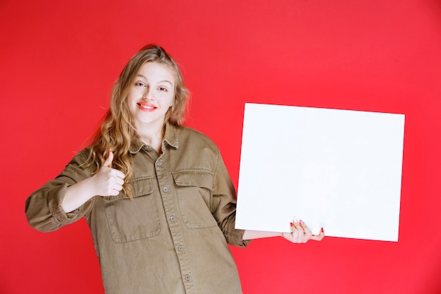 Photo gratuite fille blonde à la recherche d'une toile et en profiter.