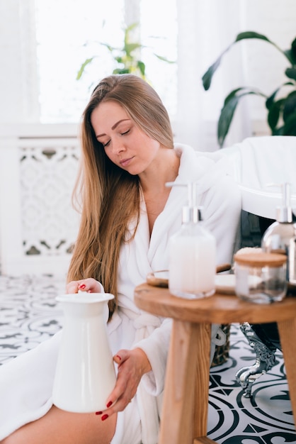 Photo gratuite fille blonde se prépare dans la salle de bain