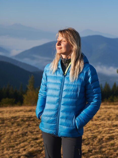 Fille blonde seule marchant dans les montagnes