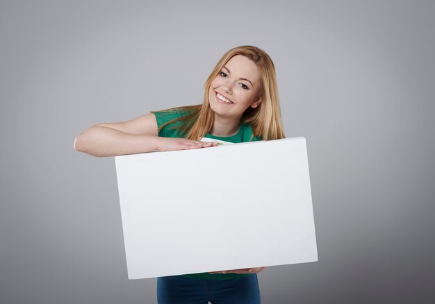 Fille blonde avec tableau blanc vide