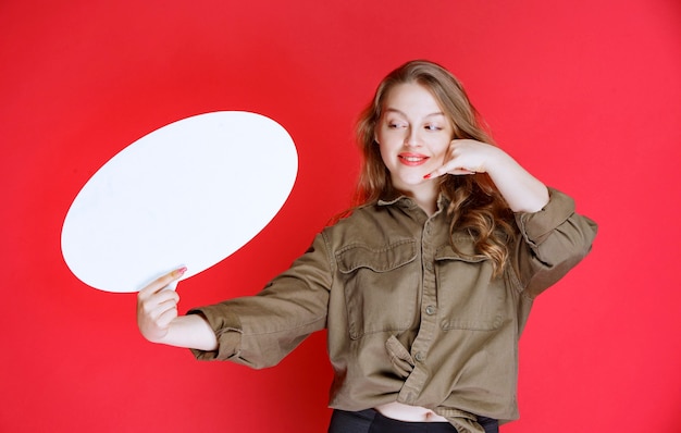 Fille blonde avec un tableau ovale demandant un contact.