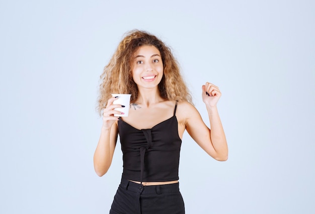 Fille blonde tenant une tasse de café comme routine matinale.