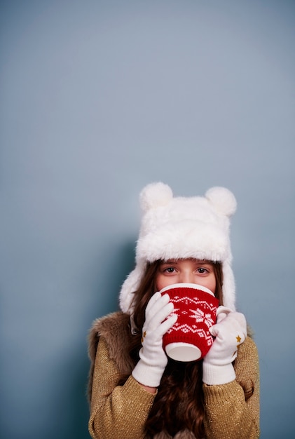 Fille de boire du chocolat chaud au studio shot