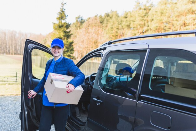 Fille avec boîte travaillant dans le service de livraison