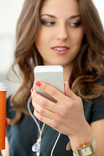 Fille bouclée avec téléphone portable