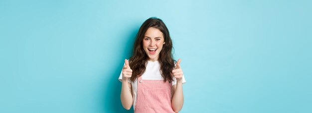 Une fille brune confiante et joyeuse dit oui en pointant du doigt l'appareil photo et en louant impertinent y