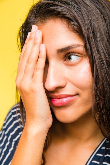 Fille brune avec la main sur le visage