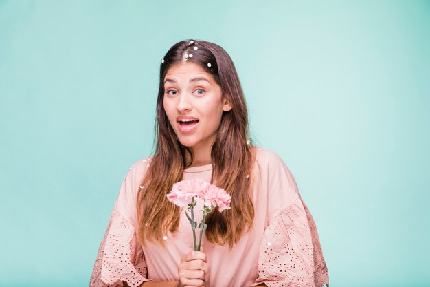 Fille brune posant avec des fleurs