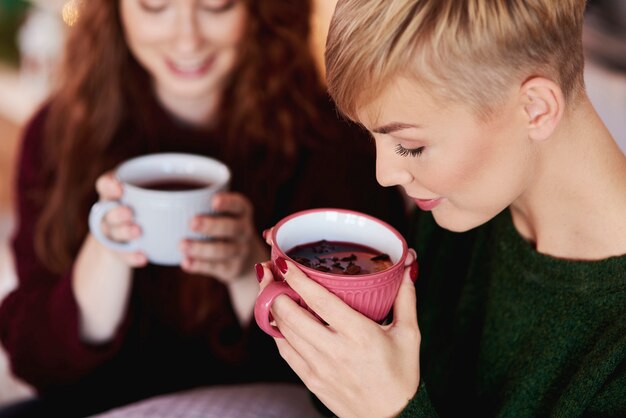 Fille buvant du thé chaud ou du vin chaud