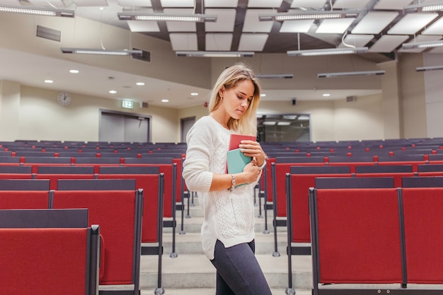 Photo gratuite fille avec des cahiers dans la salle de conférence