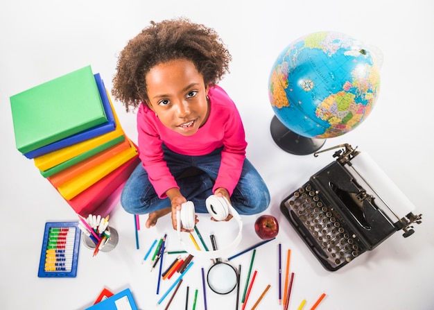 Photo gratuite fille avec un casque assis avec des outils d'étude en studio