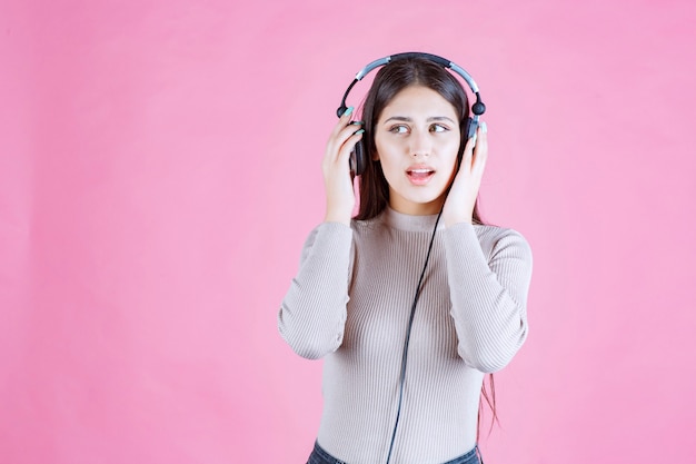 Fille avec un casque vérifiant la musique et a l'air sérieux