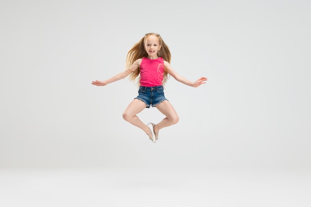 Fille caucasienne isolée sur fond de mur de studio blanc