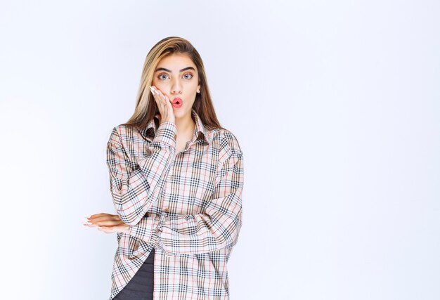 Fille en chemise à carreaux a l'air effrayée et terrifiée