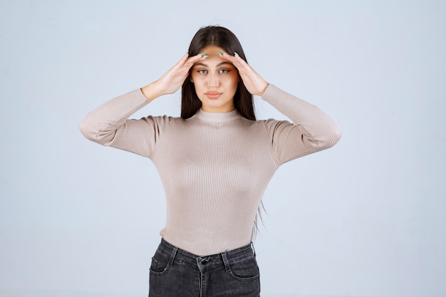 Fille en chemise grise donnant des poses invitantes et séduisantes.