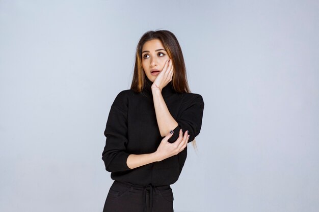 La fille en chemise noire a l'air ravie et effrayée. photo de haute qualité