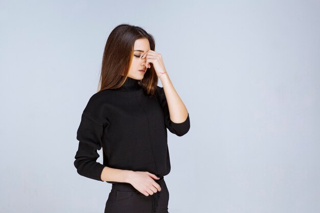 La fille en chemise noire a l'air réfléchie. photo de haute qualité