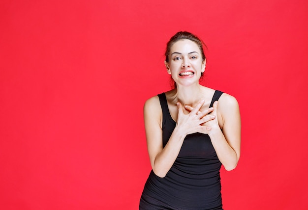 Fille en chemise noire pointant sur elle-même. photo de haute qualité