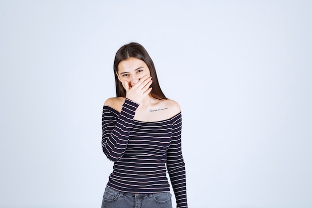 Fille en chemise rayée a l'air terrifiée et effrayée.