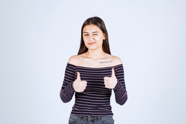 Fille en chemise rayée faisant signe de jouissance.