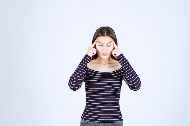 Fille en chemise rayée pensant et analysant.