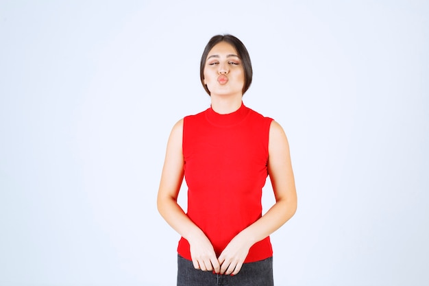 Fille en chemise rouge donnant des poses charmantes et séduisantes.