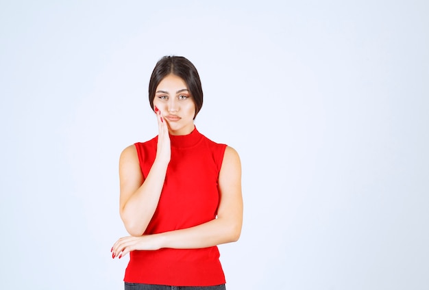 Fille en chemise rouge semble insatisfaite.