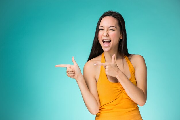 La fille chinoise heureuse sur fond jaune