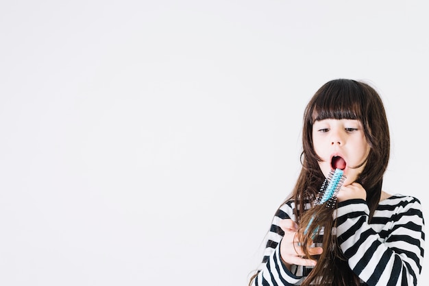 Fille choquée essayant de peigner les cheveux