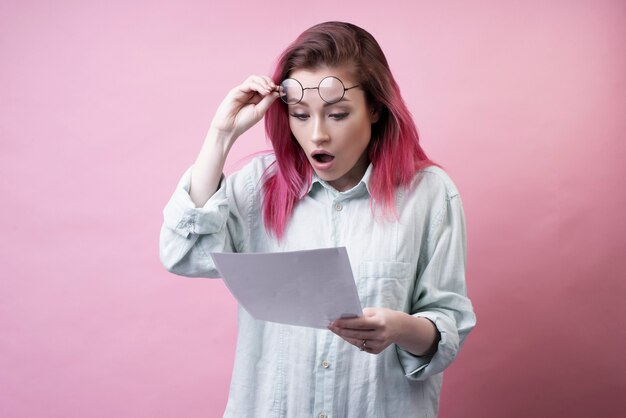 Fille choquée avec des lunettes et du papier