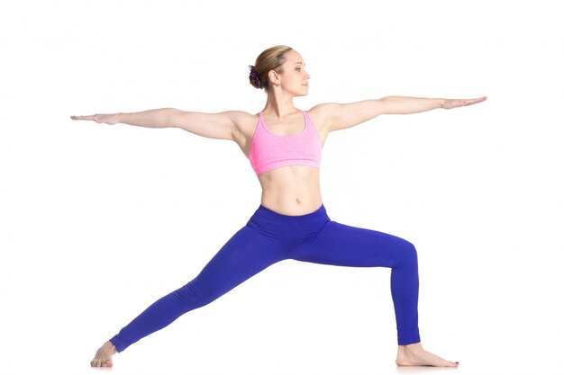 fille concentrée à pratiquer le yoga guerrier pose