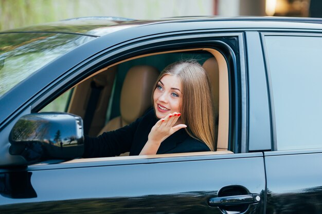 Fille conduire voiture et regarder de la fenêtre avec pedastrian