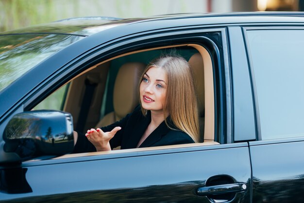 Fille conduire voiture et regarder de la fenêtre avec pedastrian