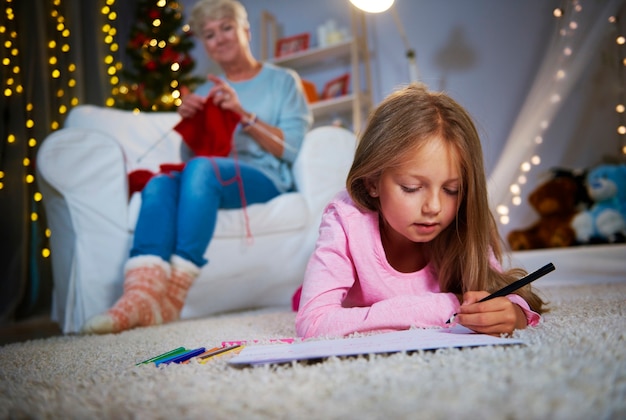 Fille couchée sur le devant et dessin