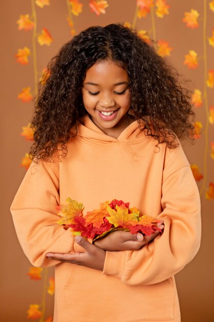 Fille de coup moyen avec des feuilles colorées