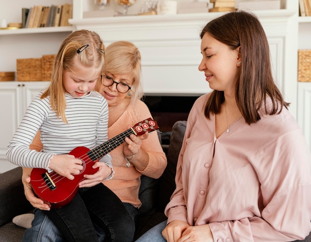 Fille de coup moyen jouant de la guitare