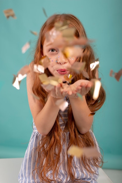 Fille de coup moyen posant avec des confettis